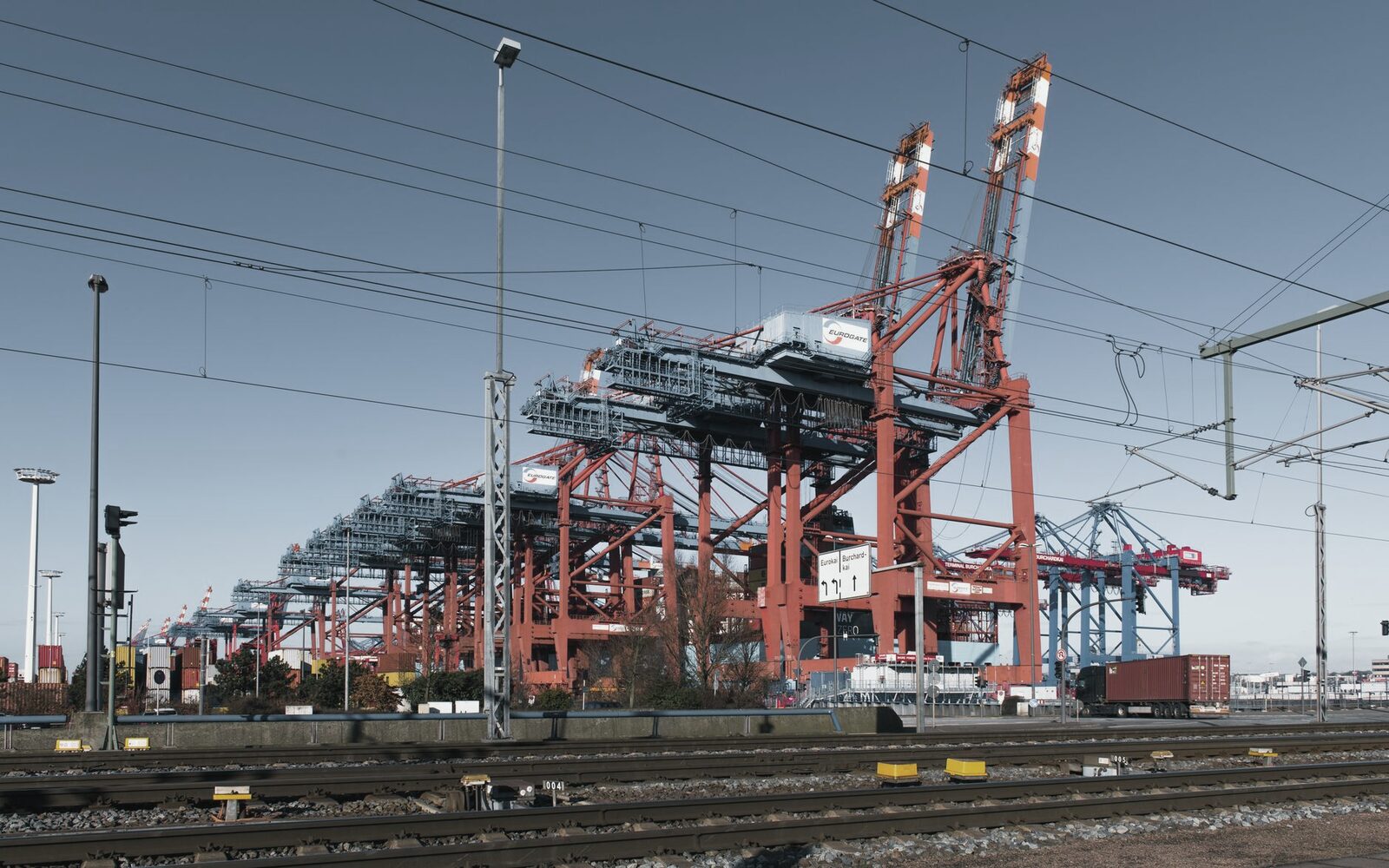 Container cranes and stacked freight at an international port terminal